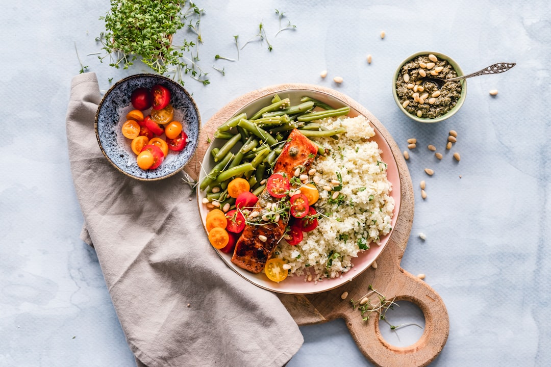 A colorful assortment of plant-based foods rich in protein, including legumes, nuts, and grains, arranged on a wooden table.