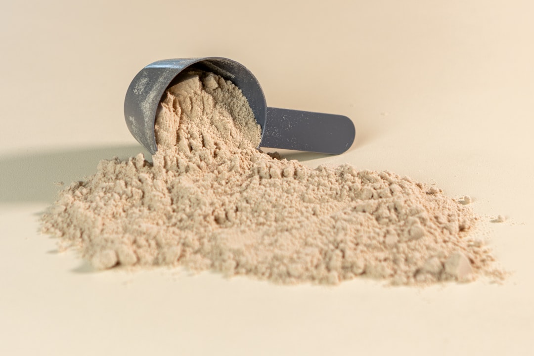 A variety of vegan protein powders in different containers, with a focus on natural ingredients like peas, rice, and hemp seeds.