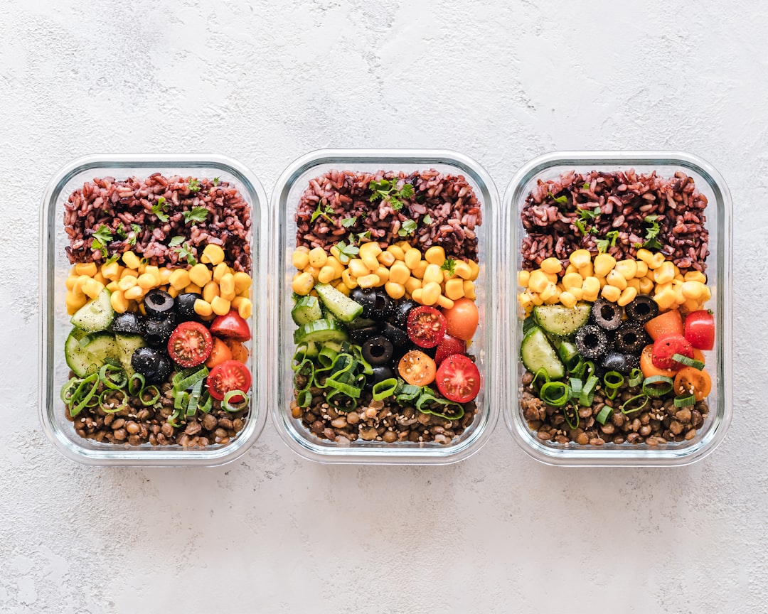 A colorful assortment of vegan meals and snacks arranged on a table, showcasing healthy options for pre and post workout nutrition.