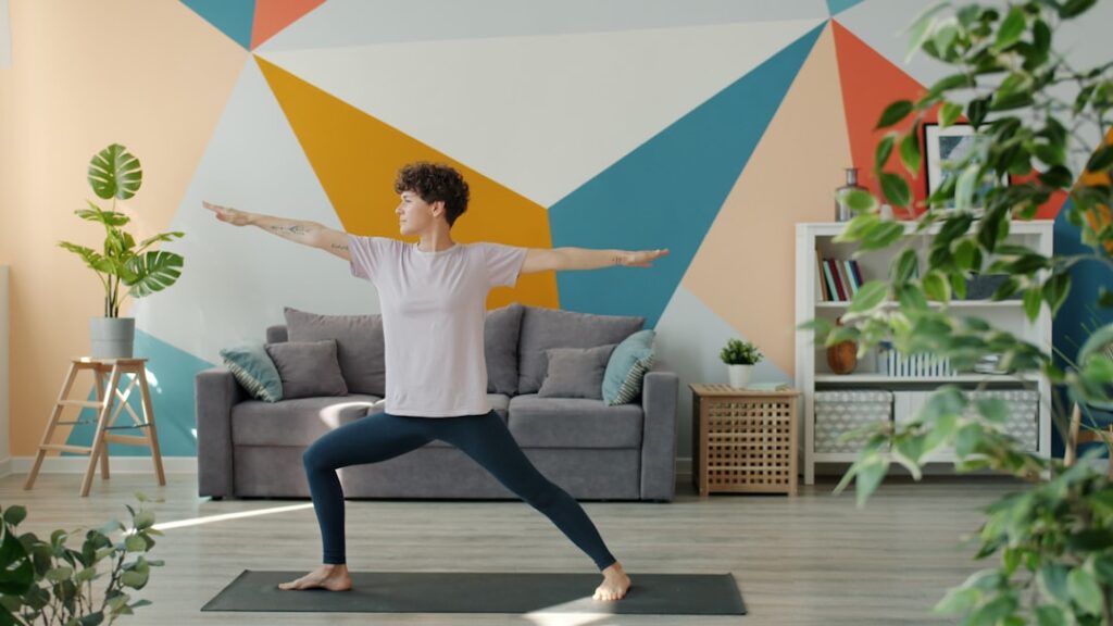 Woman practicing warrior two pose in a living room