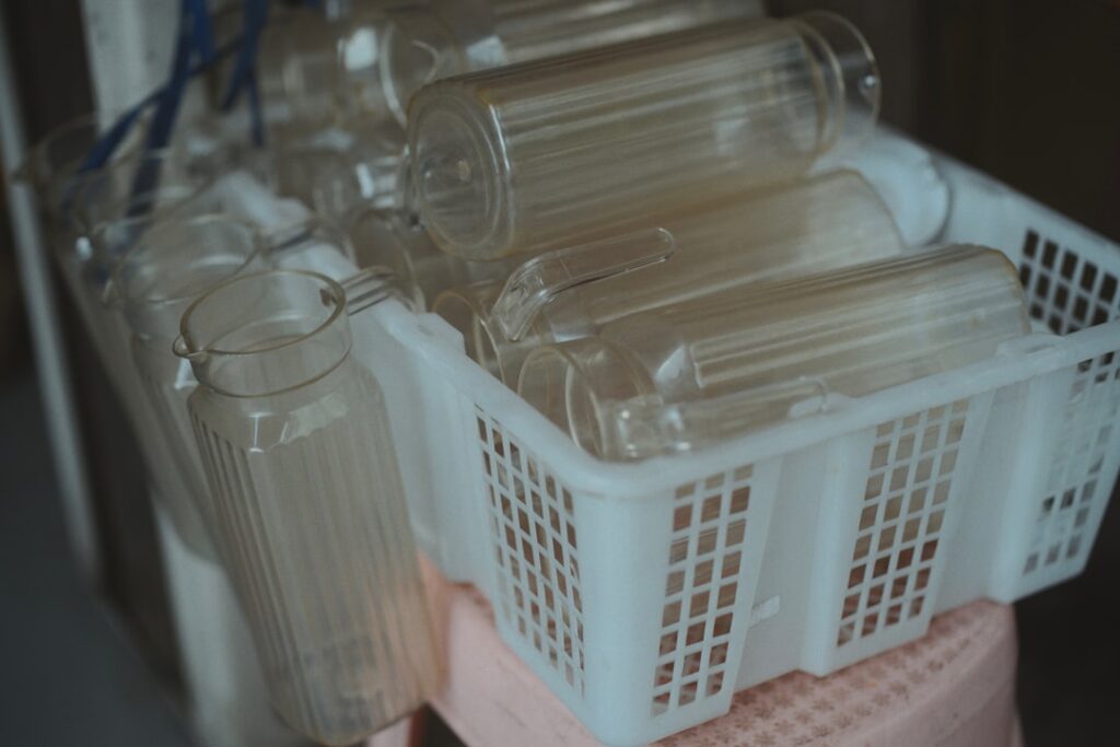 Clear glass bottles stacked in a white plastic basket